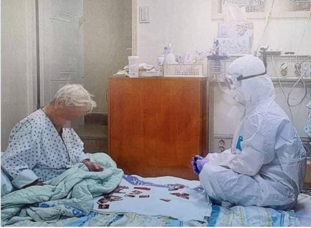 지난해 8월 1일 삼육서울병원 음압실에서 두꺼운 방호복을 입은 해 코로나19에 걸린 93세 할머니를 위해 화투를 쳐주고 잇는 이수련 간호사의 모습. 직업의식을 넘어 봉사가 무엇인지를 말해주는 이 사진에 수많은 이들이 감동했다. (SNS 갈무리) © 뉴스1
