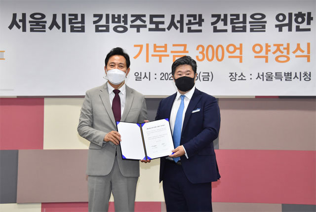 오세훈 서울시장(왼쪽)과 김병주 MBK파트너스 회장이 6일 기부약정서를 들어 보이고 있다. 서울시 제공