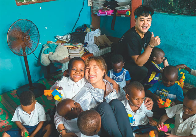 아프리카 탄자니아의 보육원 아이들과 함께 웃고 있는 김현영 홍석남 씨 부부. 두 사람은 어려운 처지에 놓인 아이들을 돕기 위해 직접 모은 후원금으로 건물을 지었다. 김현영 씨 제공