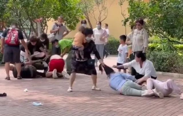아이를 안고 있는 여성이 넘어진 여성의 머리채를 잡아당기고 있다. 웨이보