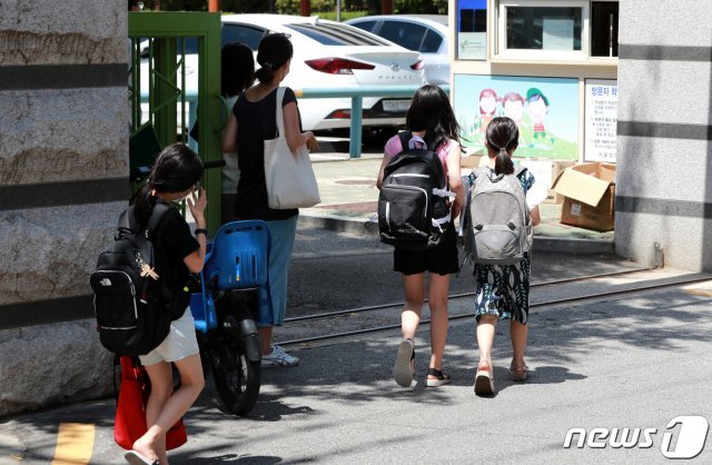 서울 한 초등학교에서 학생들이 온라인 개학식을 마치고 교과서를 받기 위해 등교하고 있다. 2021.8.9/뉴스1 © News1 구윤성 기자