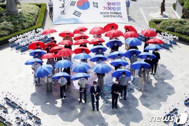제76주년 광복절을 앞둔 11일 광주 북구청 광장에서 공직자들이 우산으로 태극기 문양을 만들며 퍼포먼스를 펼치고 있다. (광주북구 제공)2021.8.11/뉴스1 © News1