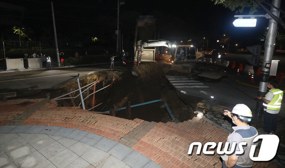 12일 대구 동구 괴전동 농수산식품유통공사 안심비축기지 인근 왕복 2차선 도로에 땅꺼짐이 일어난 가운데 관계자들이 복구작업을 하고 있다. 뉴스1