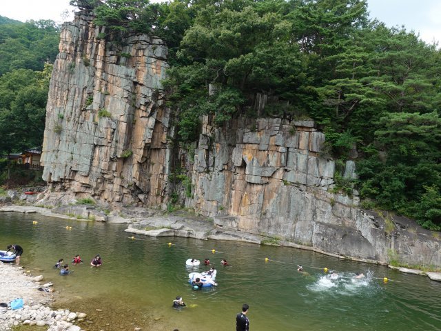 국가명승 제47호이자 단양8경 중 하나인 사인암. 관광객들이 여름 물놀이를 즐기는 동시에 암벽의 명당 기운을 암암리에 받고 있다.