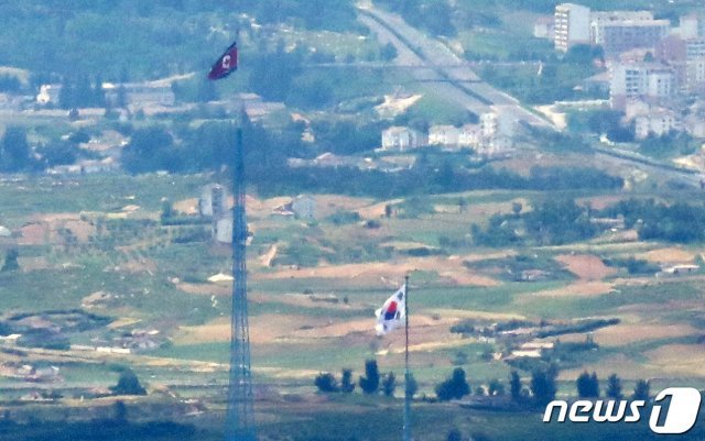 북한이 남북공동연락사무소를 폭파한 지 1년이 된 16일 오후 경기도 파주 접경 지역에서 바라본 서부전선 비무장지대(DMZ) 북한 기정동 마을의 인공기와 남한 대성동 마을의 태극기가 나란히 펄럭이고 있다. 2021.6.16/뉴스1 © News1