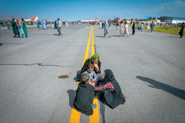 아프간 여성과 아이들, 탈레반 피해 공항으로 가족으로 보이는 여성 2명과 아이 2명이 16일(현지 시간) 아프가니스탄 수도 카불 공항 활주로 위에 앉아있다. 탈레반이 점령한 아프간에서 탈출하기 위해 사람들이 공항으로 몰려들면서 이날 수 시간 동안 공항 운영이 중단되기도 했다. 탈레반은 “여성도 히잡(스카프의 일종)만 쓴다면 교육과 일자리에 접근할 수 있고 혼자 집 밖에 나가는 것이 허용된다”고 했지만 이 약속을 믿지 않는 아프간 사람들은 ‘필사의 탈출’을 감행하고 있다. 카불=AFP