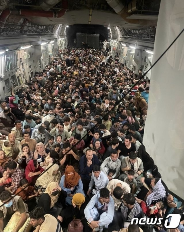 아프가니스탄 카불을 떠나 카타르로 향하는 미 공군 C-17 전투기에 아프간 민간인들이 탄 모습. (트위터 캡처)2021.8.17/뉴스1 © News1