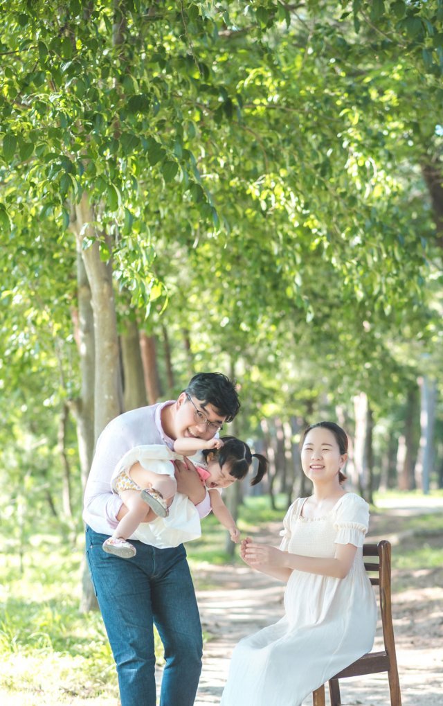 지난해 7월 강원 강릉시 허균·허난설헌기념관 소나무숲에서 딸을 안고 있는 황주성(왼쪽) 김은현 씨 부부. 김 씨는 “이곳은 주말에 아이와 함께 술래잡기나 숨바꼭질을 하면서 시간을 보내기에 제격”이라고 말했다. 김은현 씨 제공