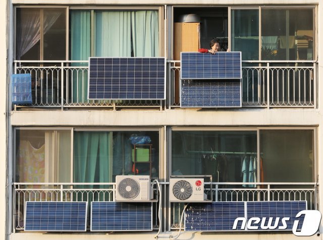 서울 노원구의 한 아파트 단지에서 한 입주민이 베란다에 설치된 태양광 판넬을 살펴보고 있다. 2017.10.24/뉴스1 © News1