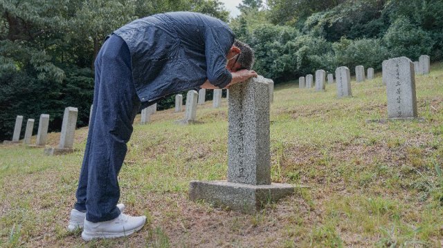20일 전남 여수시 국군묘지에서 70년 만에 아버지의 묘지를 찾은 김모 씨가 눈물을 흘리고 있다. 여수시 제공