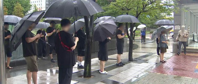 장대비가 쏟아진 21일 오후 서울 영등포구 지하철 9호선 국회의사당역 인근에서 자영업자들이 정부의 ‘거리 두기 강화’ 방침에 
반발하며 검은 옷을 입고 검은 우산을 쓴 채 거리에 서 있다. 이날 자영업자 200여 명이 국회의사당 인근에 모여 ‘수도권 
소상공인 걷기 운동’에 참여했다. 채널A 화면 캡처