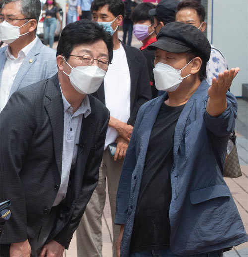 국민의힘 유승민 전 의원(왼쪽)은 이날 서울 마포구 홍대거리에서 이태진 홍대소상공인번영회장의 설명을 듣고 있다. 사진공동취재단