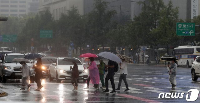 가을장마가 찾아온 21일 서울 세종대로사거리 횡단보도에서 우산을 쓴 시민들이 비를 피하며 발걸음을 재촉하고 있다. 2021.8.21/뉴스1 © News1