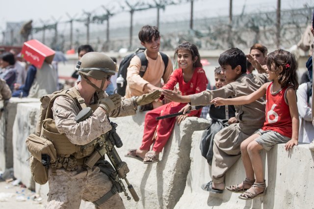 20일 미 해병대원이 아프가니스탄 카불의 하미드 카르자이 국제공항에서 잠시나마 아이들과 즐거운 시간을 보내고 있다.＜미군 제공＞