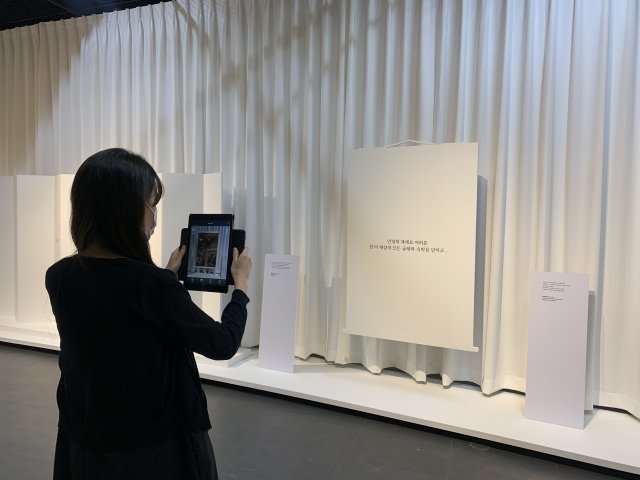 전시장을 찾은 관람객이 애니메이션 ‘이누야샤’에 나오는 대사가 쓰인 액자를 태블릿PC 카메라로 비추고 있다. 한국문화재재단 제공