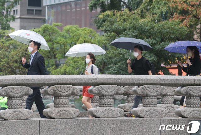 비가 보슬보슬 내린 24일 오후 서울 중구 청계천 모전교 위에서 우산을 쓴 시민들이 지나가고 있다. 2021.8.24/뉴스1 © News1