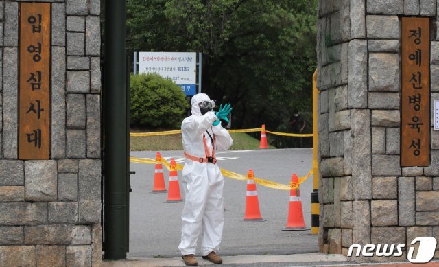 충남 논산 소재 육군훈련소 입영심사대에서 방역복 차림의 장병이 입영장병을 안내하고 있다. 2021.7.8/뉴스1 © News1