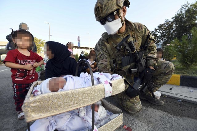 공군 최정예 특수부대 요원인 공정통제사(CCT : Combat Control Team)가 25일(현지시간) 아프가니스탄 카불공항에서 한국으로 이송될 아프간인 현지 조력자의 어린 자녀들을 수송기 탑승 전에 보살피고 있다. 공군 제공