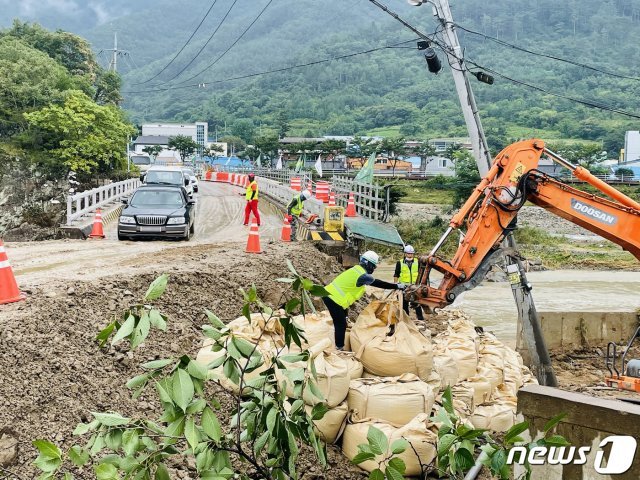 부산지방국토관리청 포항국토관리사무소 직원들이 25일 제12호 태풍 오마이스가 쏟아부은 집중 호우로 유실된 경북 포항시 북구 죽장면 국도 31호선 포항~청송 구간 입암교 구간을 밤샘 작업으로 임시 복구하고 있다. 2021.8.25/뉴스1 © News1 최창호 기자