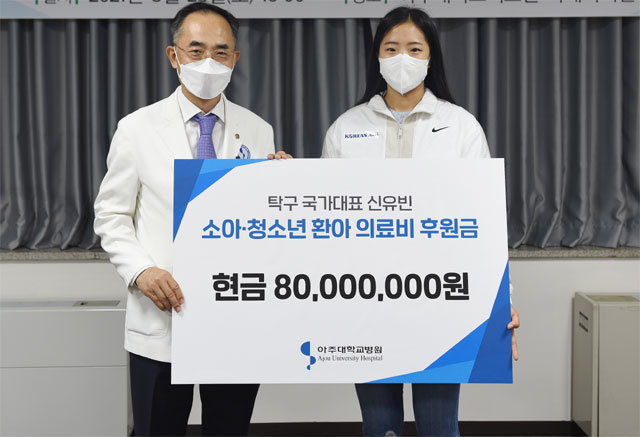 ‘탁구 신동’ 신유빈(오른쪽)이 한상욱 아주대병원장에게 소아·청소년 환아를 위해 8000만 원을 기부하고 있다. 매니지먼트GNS 제공