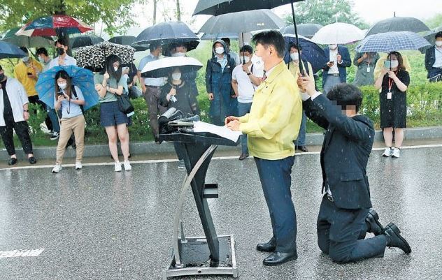 27일 충북 진천군에서 강성국 법무부 차관 브리핑 도중 수행비서가 무릎을 꿇고 우산을 받쳐주고 있다. 진천=뉴시스
