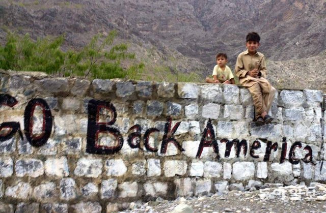 아프가니스탄과의 접경지역에 있는 파키스탄 토르크햄 마을 입구. 아프가니스탄 난민 아이들이 ‘미국은 물러가라’는 영문 글자가 선명하게 쓰인 돌담 위에 앉아 있다. 2001년 9월 21일