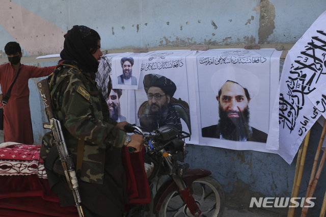 지도자 사진 바라보는 탈레반 병사.