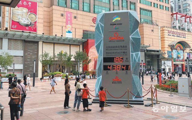 지난달 30일 중국 베이징 중심가 왕푸징에서 시민들이 베이징 겨울올림픽 카운트다운 시계탑을 바라보고 있다. 올림픽 개회까지 186일 남았음을 보여주고 있다. 베이징=김기용 특파원 kky@donga.com