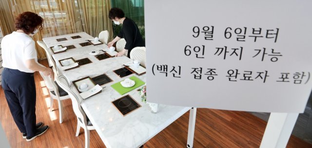 사회적 거리두기 조정안 도입을 하루 앞둔 5일 서울 종로구 일품당 프리미엄에서 직원들이 6인 손님맞이를 준비하고 있다. 뉴스1