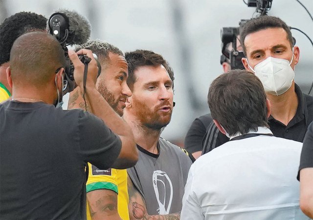아르헨티나의 리오넬 메시(가운데)와 브라질의 네이마르(왼쪽에서 두 번째)가 6일 브라질 상파울루의 네오쿠이미카 아레나에서 열린 브라질과 아르헨티나의 2022 카타르 월드컵 남미 예선 6차전 도중 전반 5분 만에 신종 코로나바이러스 감염증(코로나19) 방역 수칙 위반으로 경기가 갑자기 중단되자 관계자들에게 항의하고 있다. 메시는 이날 라커룸에 들어갔다가 다시 나왔는데 유니폼 대신 사진기자용 조끼를 입어 눈길을 끌었다. 상파울루=AP 뉴시스