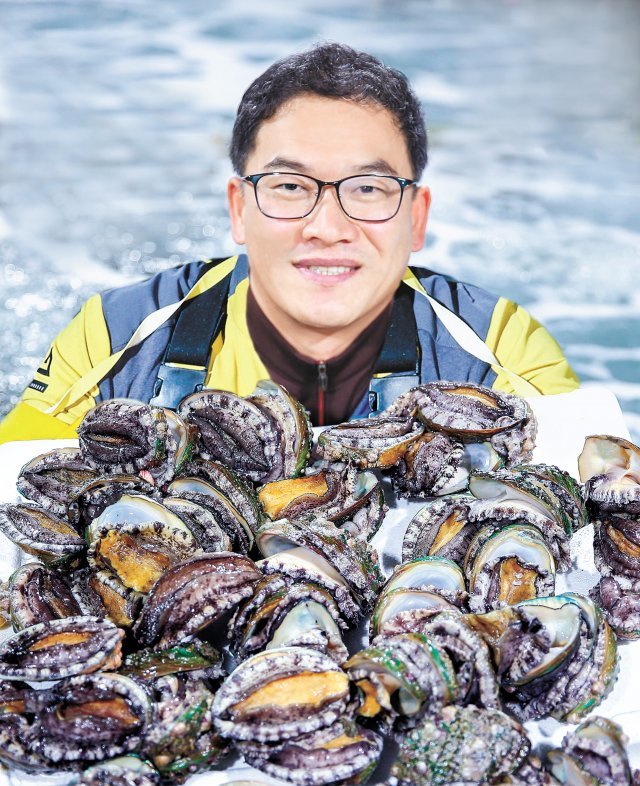 최기철 사장이 수조 안에서 전복을 보여 주고 있다. 사진=프리랜서 장정필