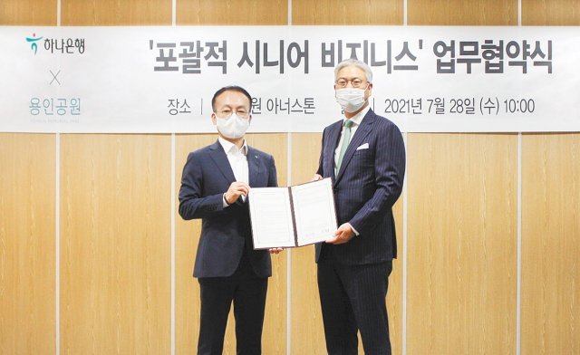김동균 용인공원 이사장(오른쪽)과 김기석 하나은행 부행장이 기념 촬영을 하고 있다.