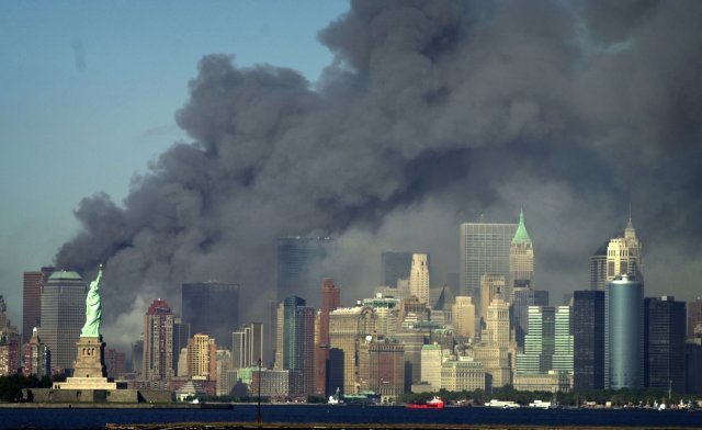 세계 무역 센터가 있던 자유의 여신상 뒤에서 짙은 연기가 하늘로 치솟고 있다. AP=뉴시스