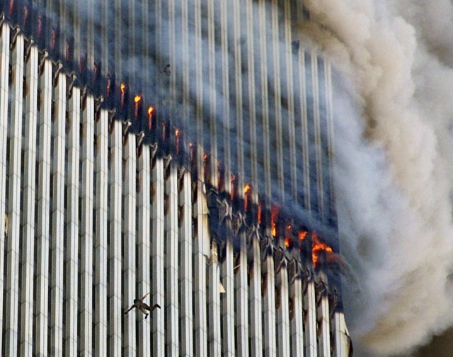건물에서 연기와 불이 뿜어져 나오는 동안 한 사람이 뉴욕 세계 무역 센터의 북쪽 타워에서 떨어지고 있다. AP=뉴시스