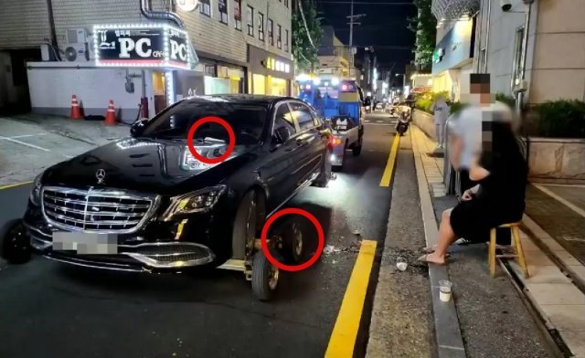 피견인 차량 앞유리 와이퍼에 껴있던 부정주차 스티커를 구경하던 여성이 보조바퀴에 발이 끼었다. (유튜브 ‘한문철TV’ 영상 갈무리) © 뉴스1