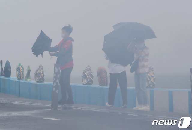 제14호 태풍 ‘찬투(CHANTHU)’가 북상 중인 14일 오전 제주시 용담해안도로에서 우산을 쓴 행인들이 발걸음을 옮기고 있다. 2021.9.14/뉴스1 © News1