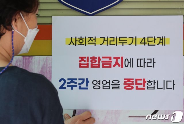 대전 유성구에 위치한 노래방에서 주인이 영업중단을 알리는 안내문을 붙이고 있다. 2021.8.9/뉴스1 © News1