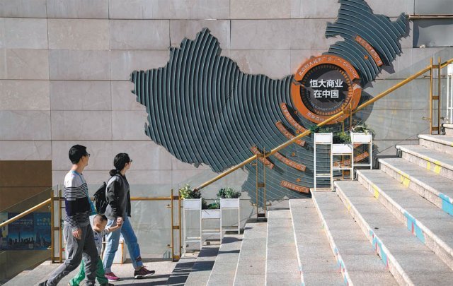 중국 베이징의 헝다그룹 시티 플라자 계단에 헝다그룹의 개발 프로젝트를 설명하는 장식물이 설치된 벽을 시민들이 지나치고 있다. 베이징=AP 뉴시스