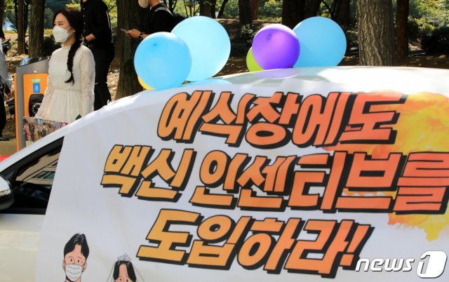 전국신혼부부연합회 회원이 지난 15일 오전 서울 영등포구 여의도공원 인근 공영주차장에서 ‘웨딩카 주차 및 1인 시위’를 하는 모습. © News1