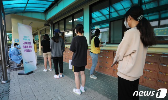 23일 오전 서울 중구 한 중학교에서 추석 연휴 이후 학생 확진자 확산을 막기 위해 마련된 이동식 PCR 검사소에서 학생과 교직원들이 검사를 받기 위해 줄지어 기다리고 있다. © News1