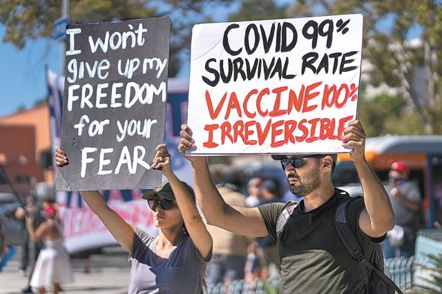 18일 백신 의무화 조치에 반발한 시민들이 캘리포니아주 로스앤젤레스 시청 앞에서 ‘당신의 두려움 때문에 내 자유를 포기하지 
않겠다’ ‘코로나19 생존율은 99%지만 백신은 100% 돌이킬 수 없다’ 등의 팻말을 들고 시위를 벌이고 있다. 
뉴욕·로스앤젤레스=AP 뉴시스