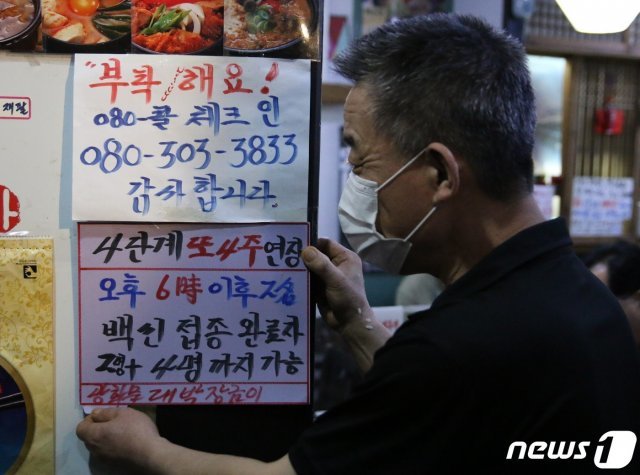 24일 서울 광화문의 한 음식점에서 관계자가 백신 인센티브 관련 문구가 적힌 안내문을 붙이고 있다. 2021.9.24/뉴스1 © News1