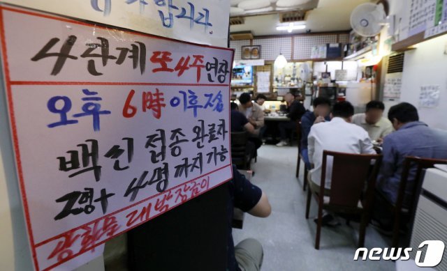 서울 광화문의 한 음식점에서 관계자가 백신 인센티브 관련 문구가 적힌 안내문을 붙이고 있다./뉴스1 © News1