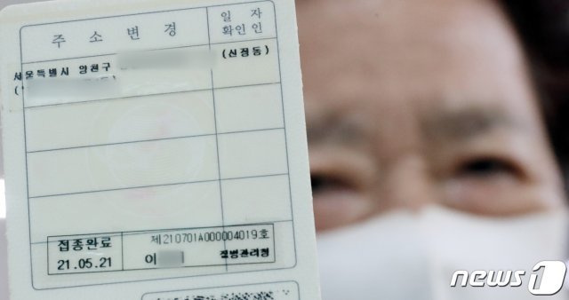 서울 양천구 신정1동 주민센터에서 코로나19 백신 접종완료 스티커를 들어 보이고 있다./뉴스1 © News1