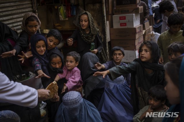 16일(현지시간) 아프가니스탄 카불의 한 빵집 앞에서 여성과 아이들이 나눠주는 빵을 받고 있다. 카불=AP/뉴시스