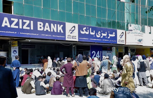 아프가니스탄 사람들이 은행 사무실 밖에서 줄을 서고 있다. 아프가니스탄의 ATM과 은행 사무실의 50%가 현금 부족으로 문을 닫았다. TASS via (GettyImages)/코리아