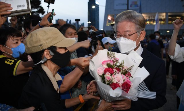 58%의 득표율을 기록하며 압승을 거둔 이재명 더불어민주당 경선 후보가 3일 오후 인천 연수구 송도컨벤시아에서 열린 더불어민주당 제20대 대통령선거 후보자 선출을 위한 인천 합동연설회(2차 슈퍼위크)를 마친 후 지지자들에게서 꽃다발을 전달받고 있다. 2021.10.3/뉴스1 © News1