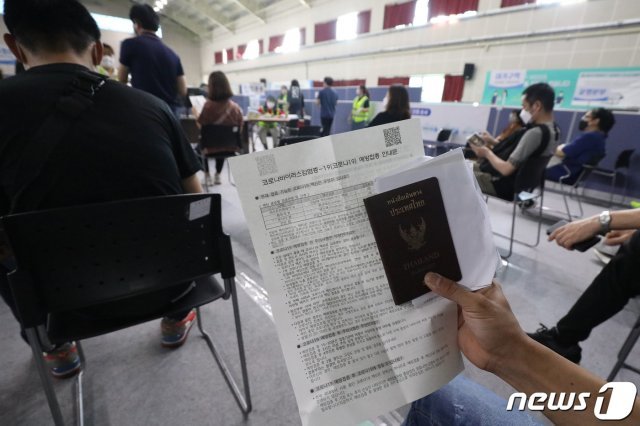 5일 오후 대구 달서구 성서예방접종센터에서 여권을 손에 든 외국인 근로자들이 코로나19 백신 접종 순서를 기다리고 있다. 2021.10.5/뉴스1 © News1