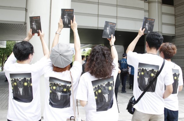 앞면은 조국 전 장관, 뒷면은 정겸심 교수 사진이 프린팅 된 티셔츠를 단체로 입은 지지자들이 지난 7월 9일 서울 서초구 중앙지방법원에서 열린 조 장관 공판에 앞서 그를 응원하고 있다. 뉴스1
