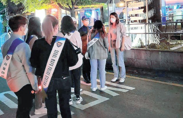 7일 오후 서울 마포구 홍익대 인근 거리의 외국인들이 많이 찾는 술집 앞. 네팔 출신 스마리카 바스네트 씨와 심재복 마포경찰서 홍익지구대장이 외국인 방문객에게 방역수칙 숙지 여부를 묻고 잘 지켜줄 것을 당부하고 있다. 홍익지구대 제공